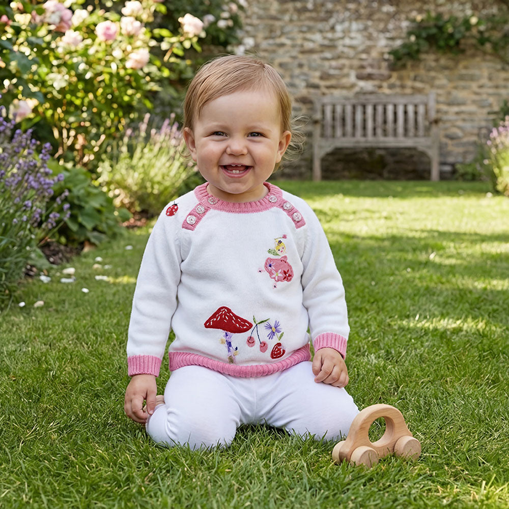 Baby wearing Fairy Knitted Jumper in garden