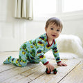 Baby wearing Countryside Print Jumpsuit With Feet crawling on a wooden floor