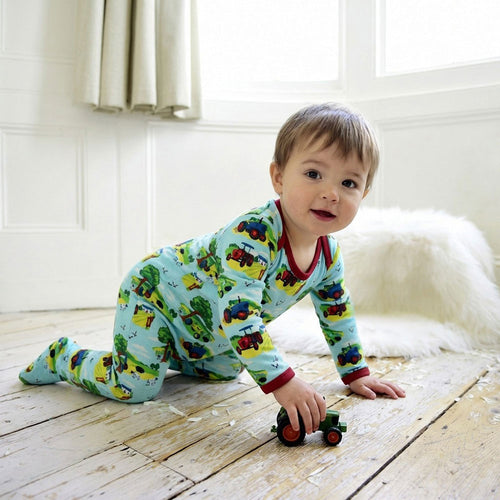 Baby wearing Countryside Print Jumpsuit With Feet crawling on a wooden floor