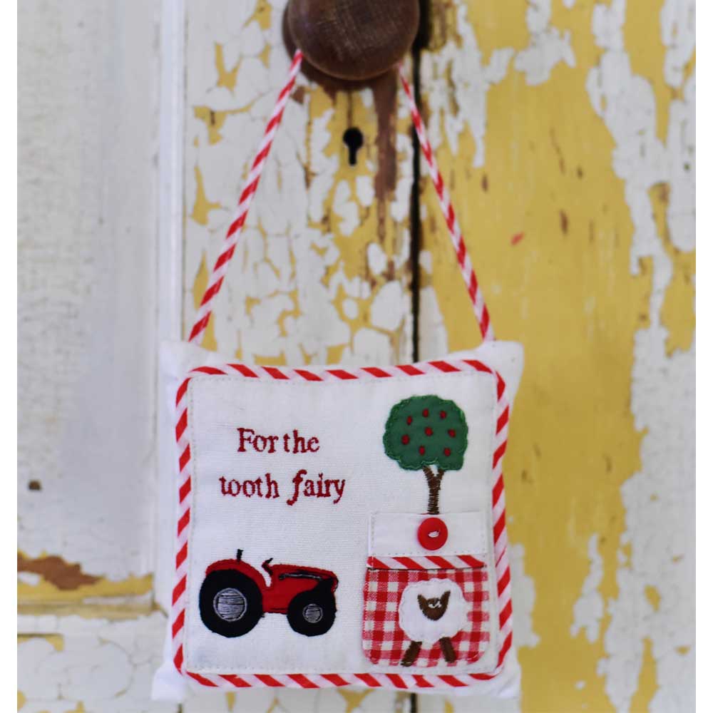 Tractor Tooth Fairy Cushion hanging on a rustic door handle