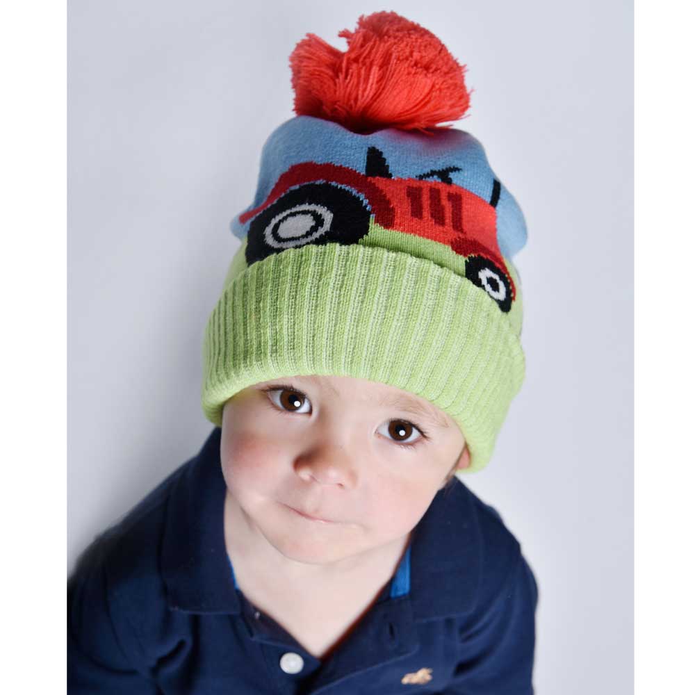 Young child wearing Tractor Hat with red pompom