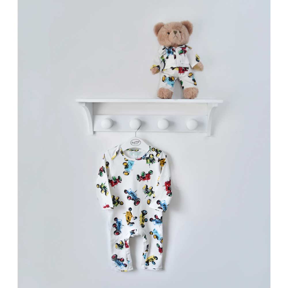 Teddy bear in tractor pyjamas on a shelf above a matching baby tractor print sleepsuit on a hanger