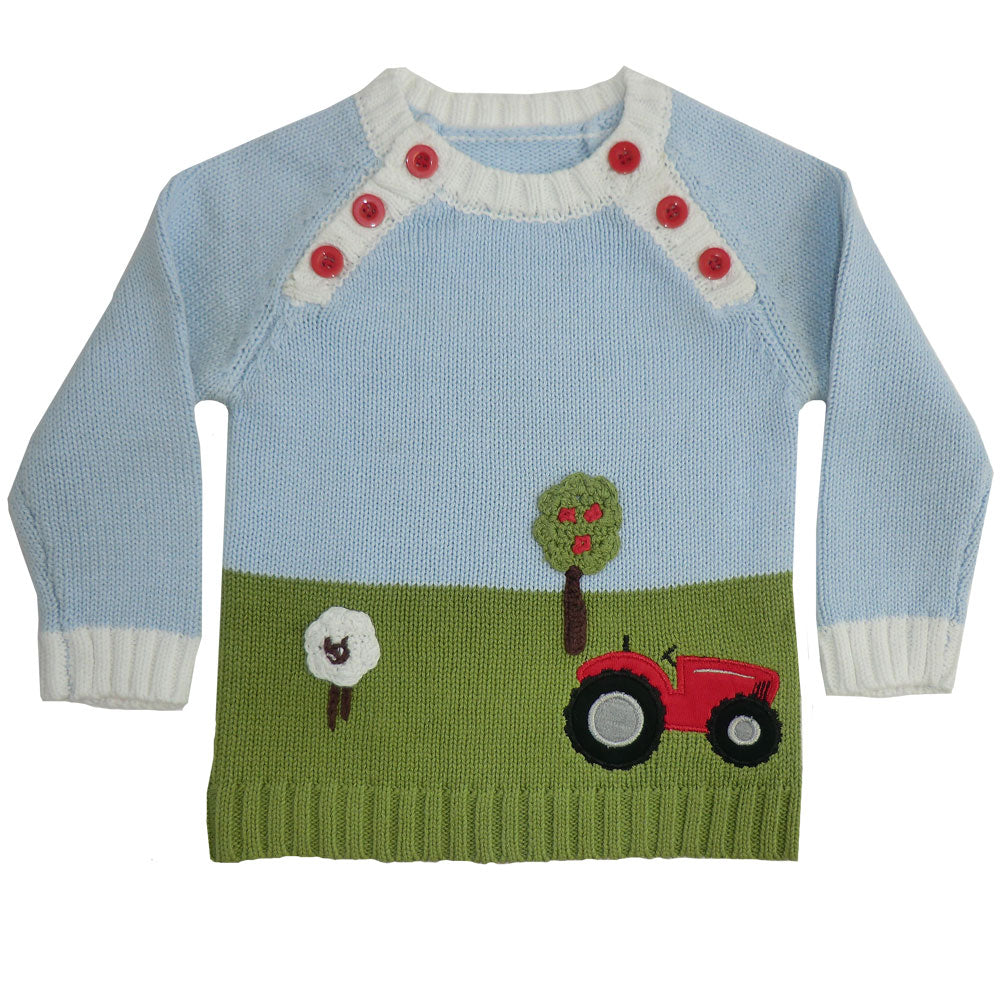 Tractor knitted jumper flat lay on white background showing farmyard scene with red tractor, sheep, and apple tree