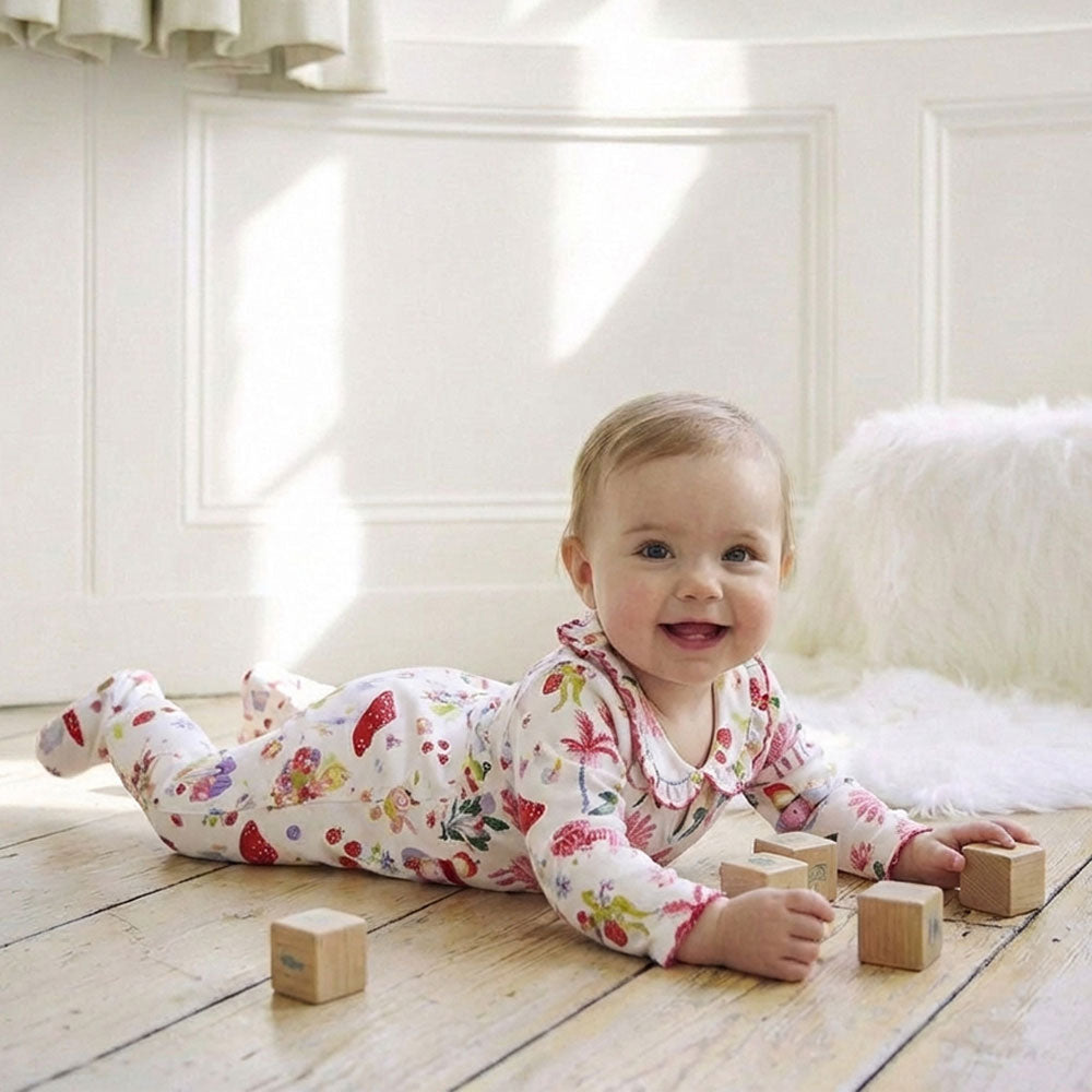 Baby wearing Fairy Print Jumpsuit on wooden floor