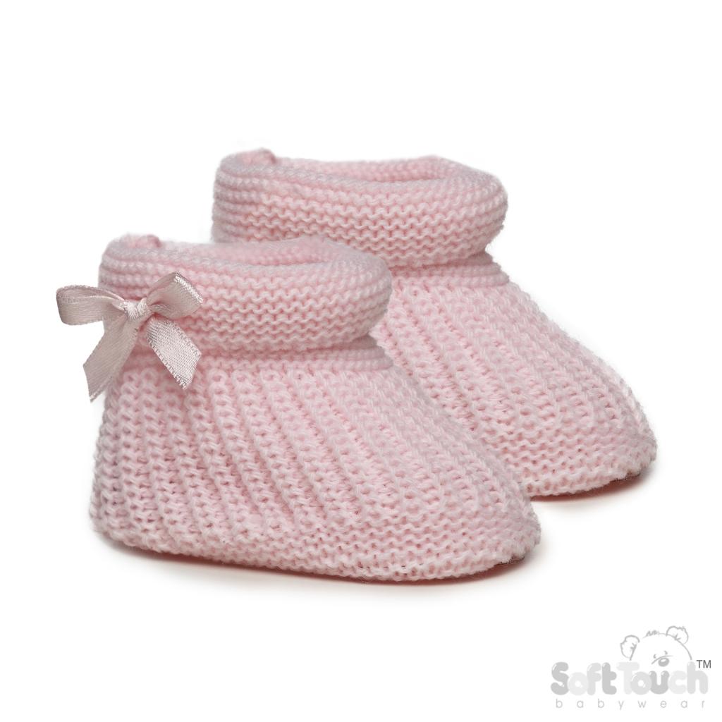 Pair of pink knitted baby booties with a bow on a white background
